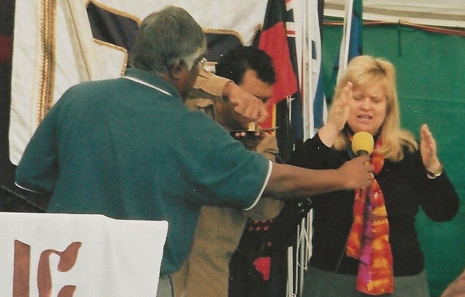Uluru conference 2005: Barbara praying, and Dr George Annadorai as Norman turns the key over a map of Australia
